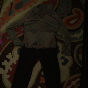 A gray top that has pink lines of black jeans